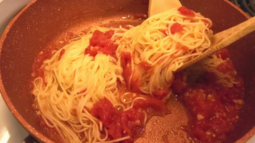 Photo of pasta tossed in sauce.